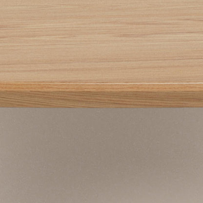 Close-up of a light natural wood tabletop surface with a smooth beveled edge, shown against a warm beige background.