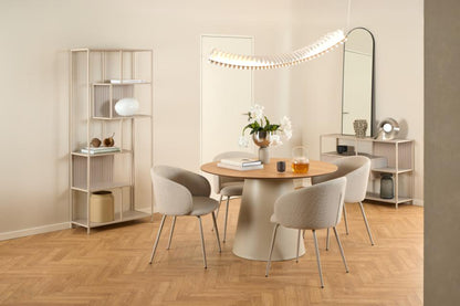 Modern Soli dining room with round table and chairs, shelves, and decorative items.