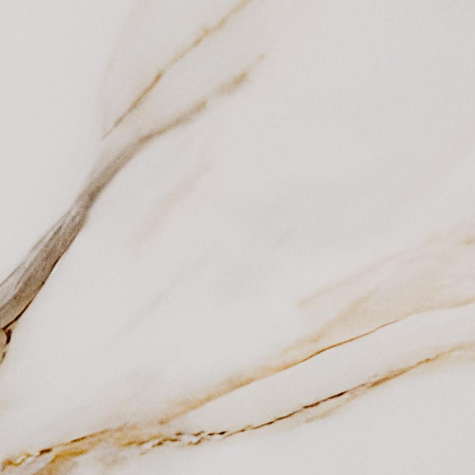 Close-up of a marble surface with beige and brown veins on a light background
