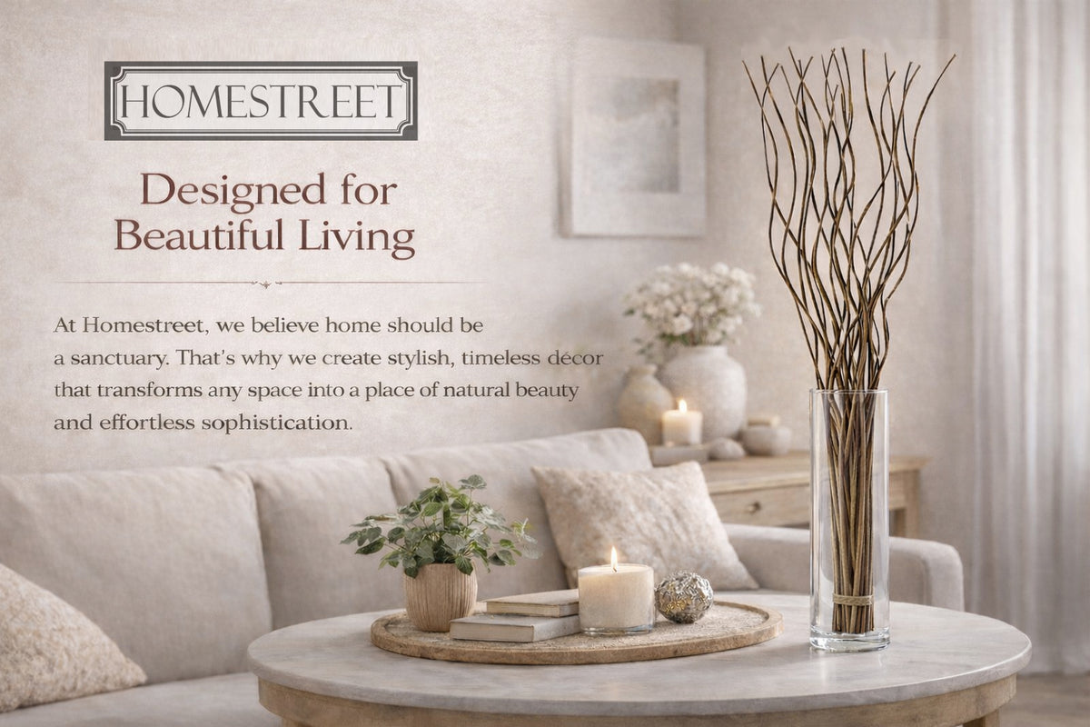 A styled living room scene with a beige sofa, round marble coffee table, candles, books, and a tall glass vase holding dried branches. Text on the left reads 'HOMESTREET' and 'Designed for Beautiful Living' with additional brand copy about creating stylish, timeless decor.