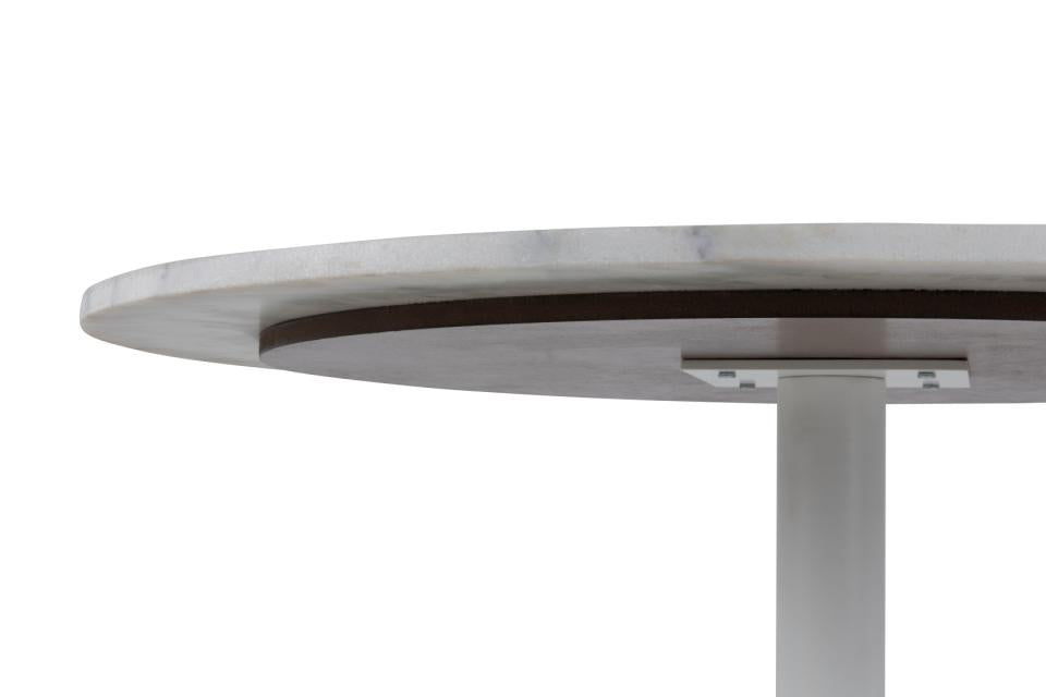 looking upwards at a white marble dining table to view the solid metal support frame