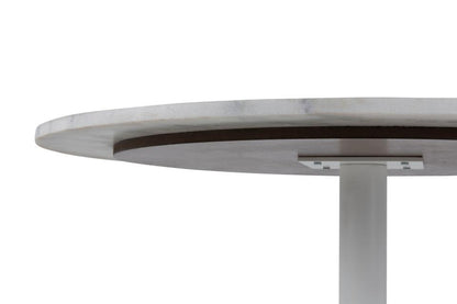 looking upwards at a white marble dining table to view the solid metal support frame