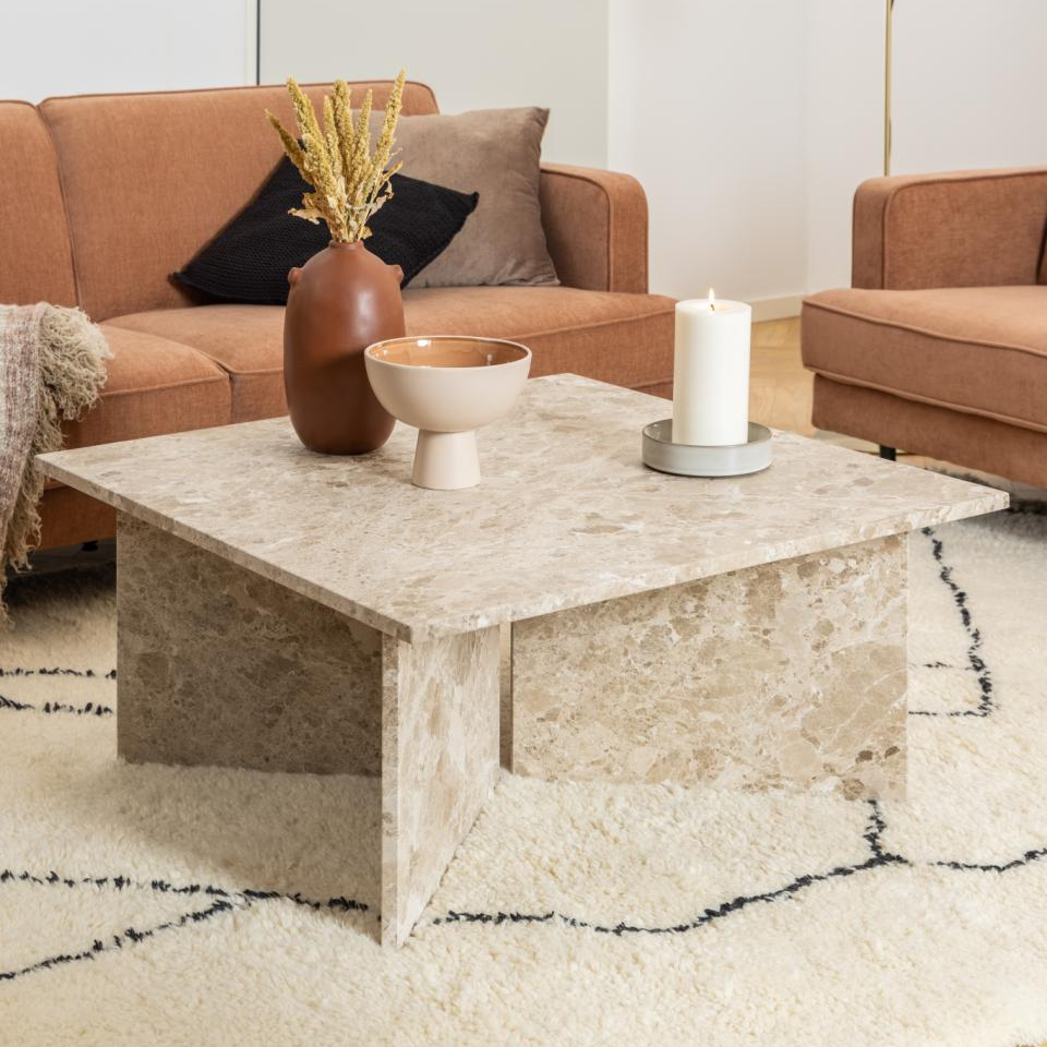 Modern living room with brown sofas, marble coffee table, and decorative elements.