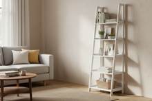 Load image into Gallery viewer, Ladder shelf in a living room with books and decor items against a beige wall.
