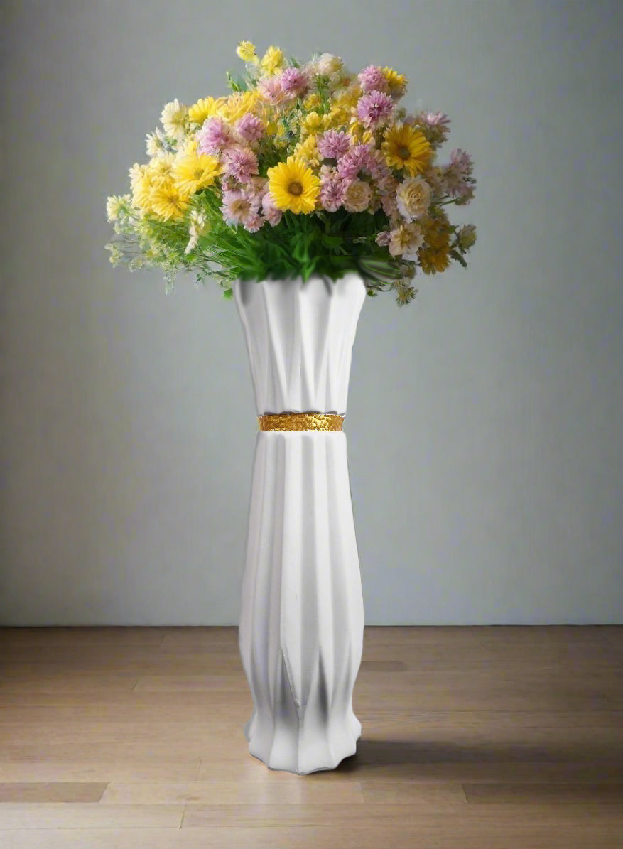 a white ceramic vase with a gold stripe with colourful flowers at the inside
