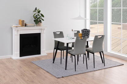Dining room with a table and chairs in front of a fireplace.