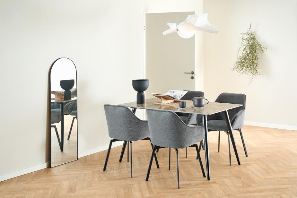 Modern dining room with a table and chairs on a wooden floor.