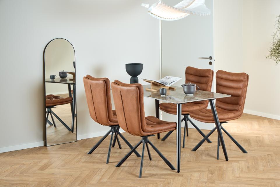 Dining room with brown chairs and a glass table near a full-length mirror.