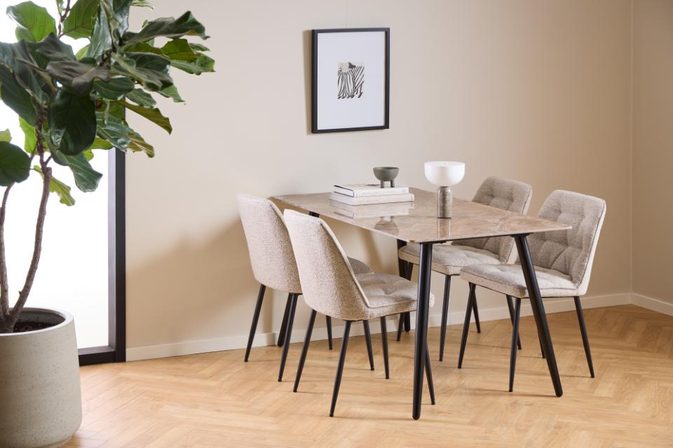 Dining room with a wooden table and chairs against a beige wall.