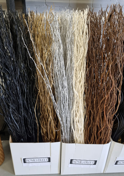 Three white bins filled with decorative twig bundles in black, tan, white, and brown, with 'Dismestreet' labels on the front.