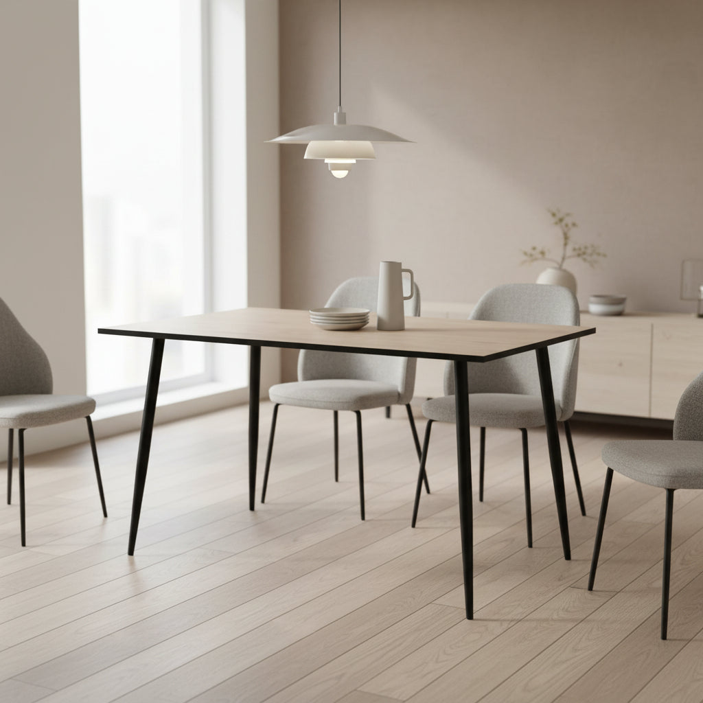 A rectangular dining table with a light beige wood-grain tabletop and four tapered black metal legs, shown against a plain white background.
