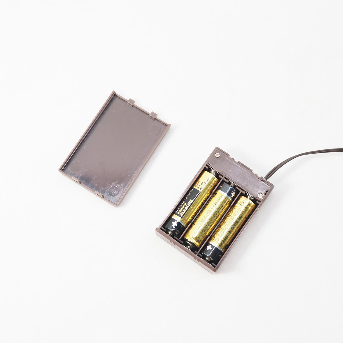 a brown battery pack with 3 x aa batteries inside on a white background