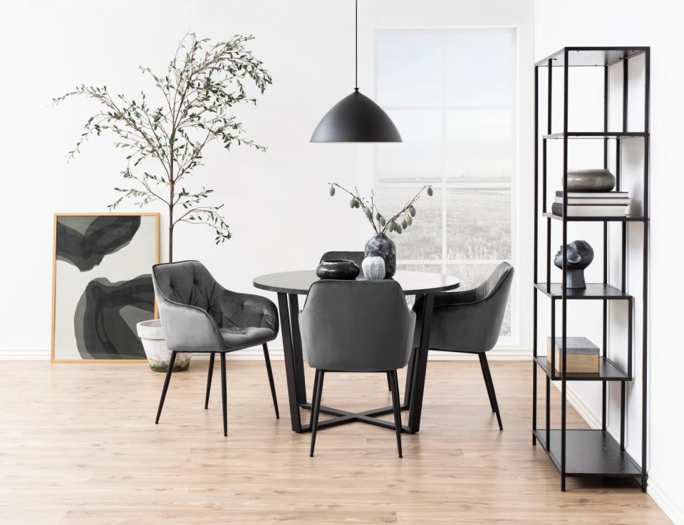 Round amble dining table with chairs and storage unit in a modern room