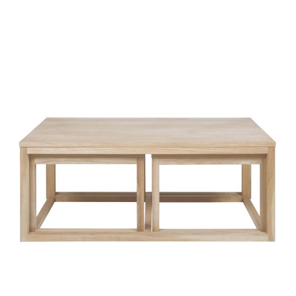 A set of three white oak veneer coffee tables of varying sizes, with a rectangular main table and two smaller side tables.