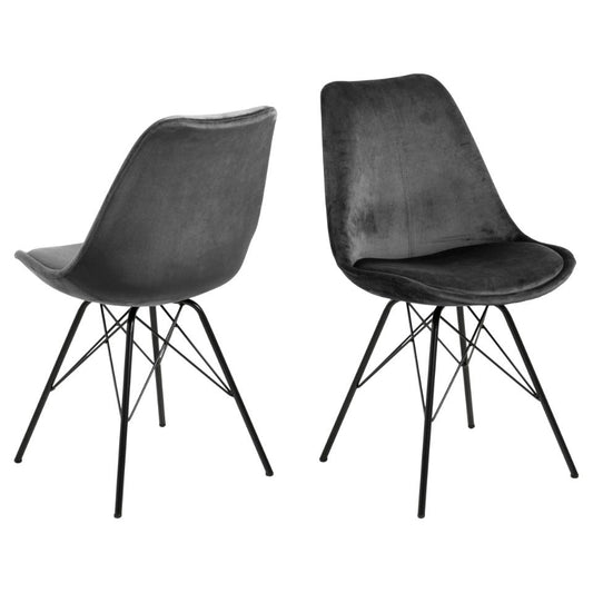 A pair of dark grey upholstered dining chairs with black metal coated bases.