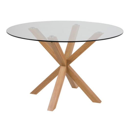 A round dining table with a clear glass top and a metal oak foil pedestal base with angular legs.